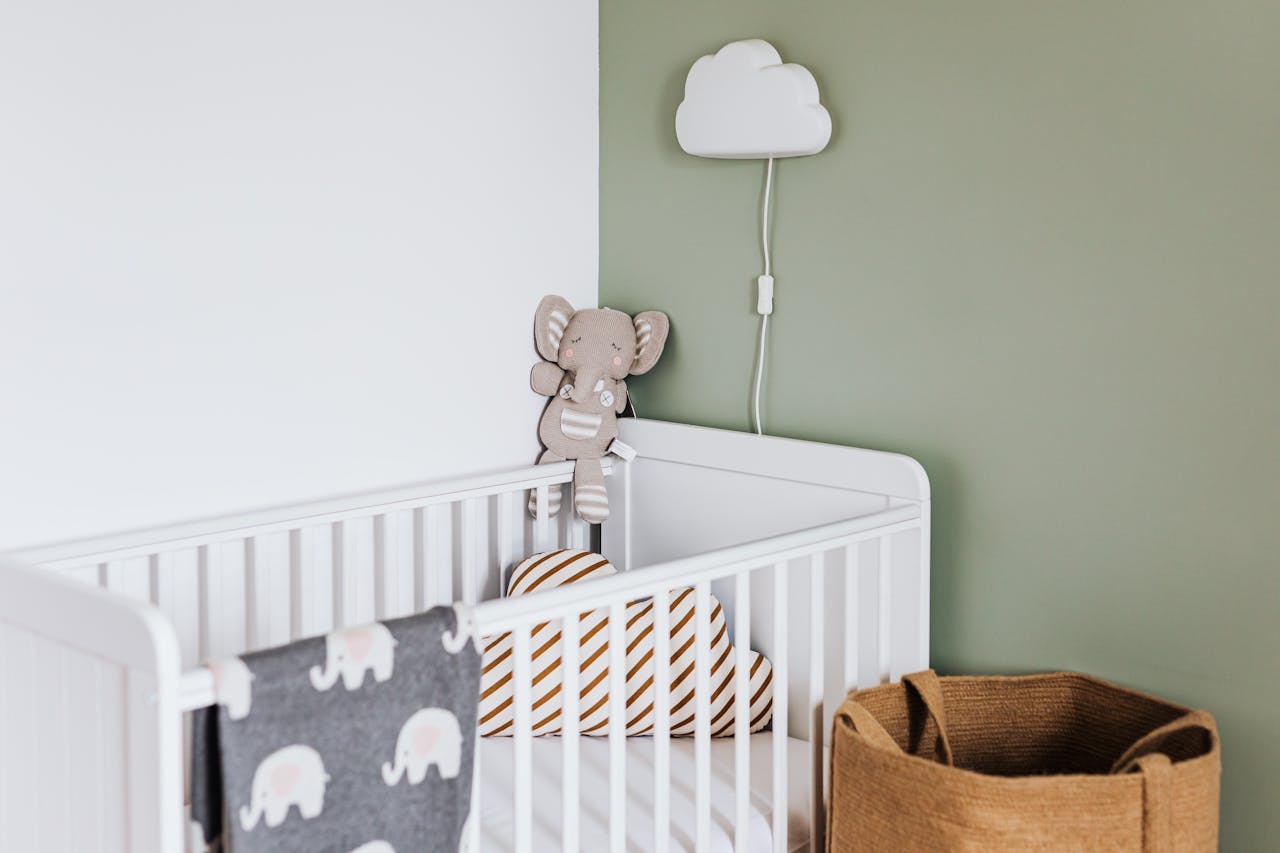 who-we-are Modern baby room featuring a white crib, soft decor, and pastel accents.